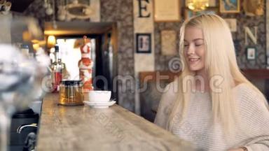 一个年轻漂亮的女人用智能手机支付她的茶，并感谢服务器。 4K.